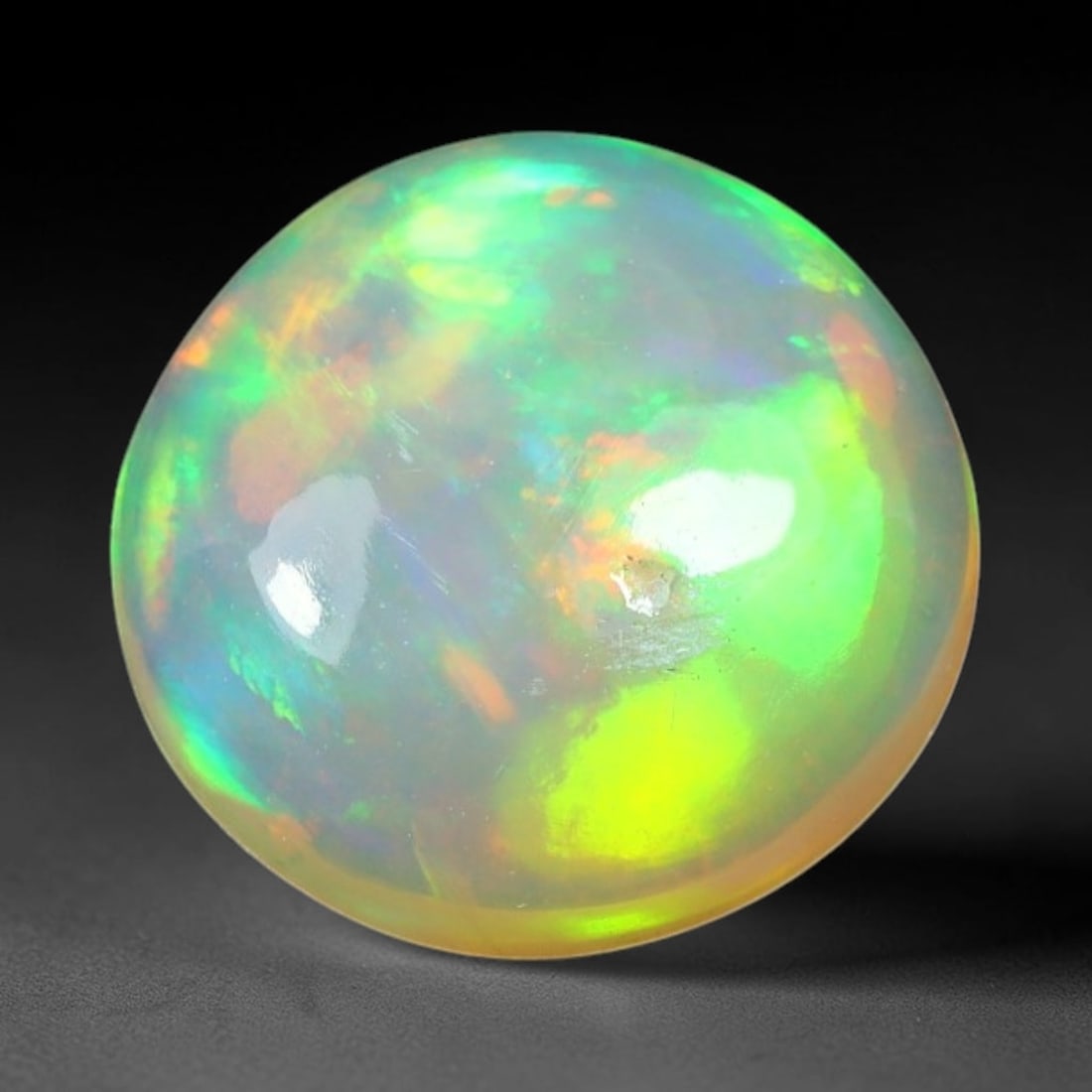 1.58ct Natural Ethiopian Welo Solid Opal Oval Cabochon Loose Gemstone, 53TG: Solid opal cabochon mined from Ethiopia's Welo opal deposits, polished into a smooth elongated oval dome with high reflective gloss. The translucent pale milky base hosts broad shifting play-of-color 