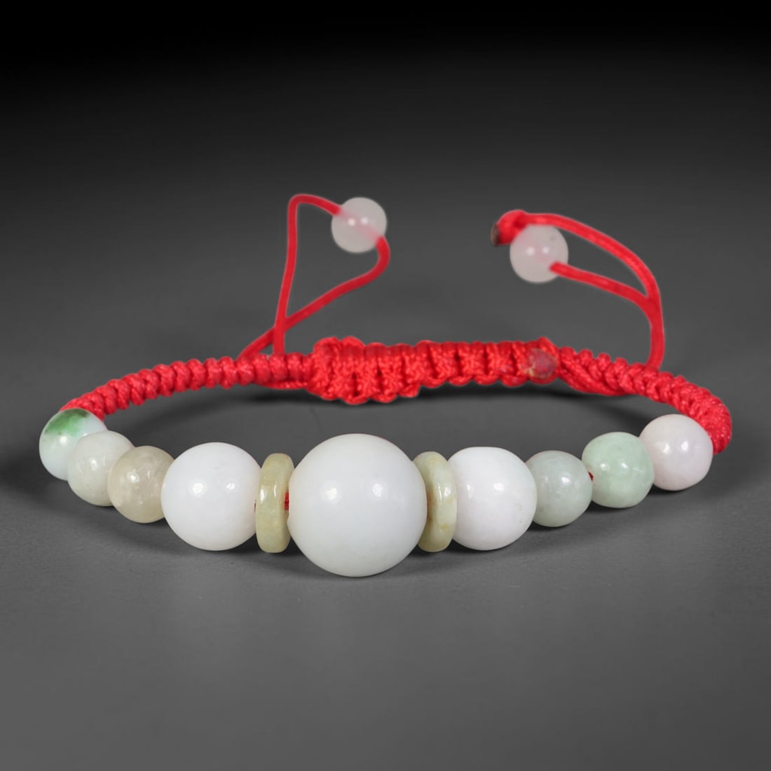 Natural Burmese Type A Milky White Round Jadeite Jade Adjustable Red Braided Bracelet, 64TA: Crafted from untreated natural Burmese Type A multi-toned jadeite, this scarlet braided cord bracelet features a prominent central spherical jadeite bead measuring 14.25 mm, framed by thin pale jade d
