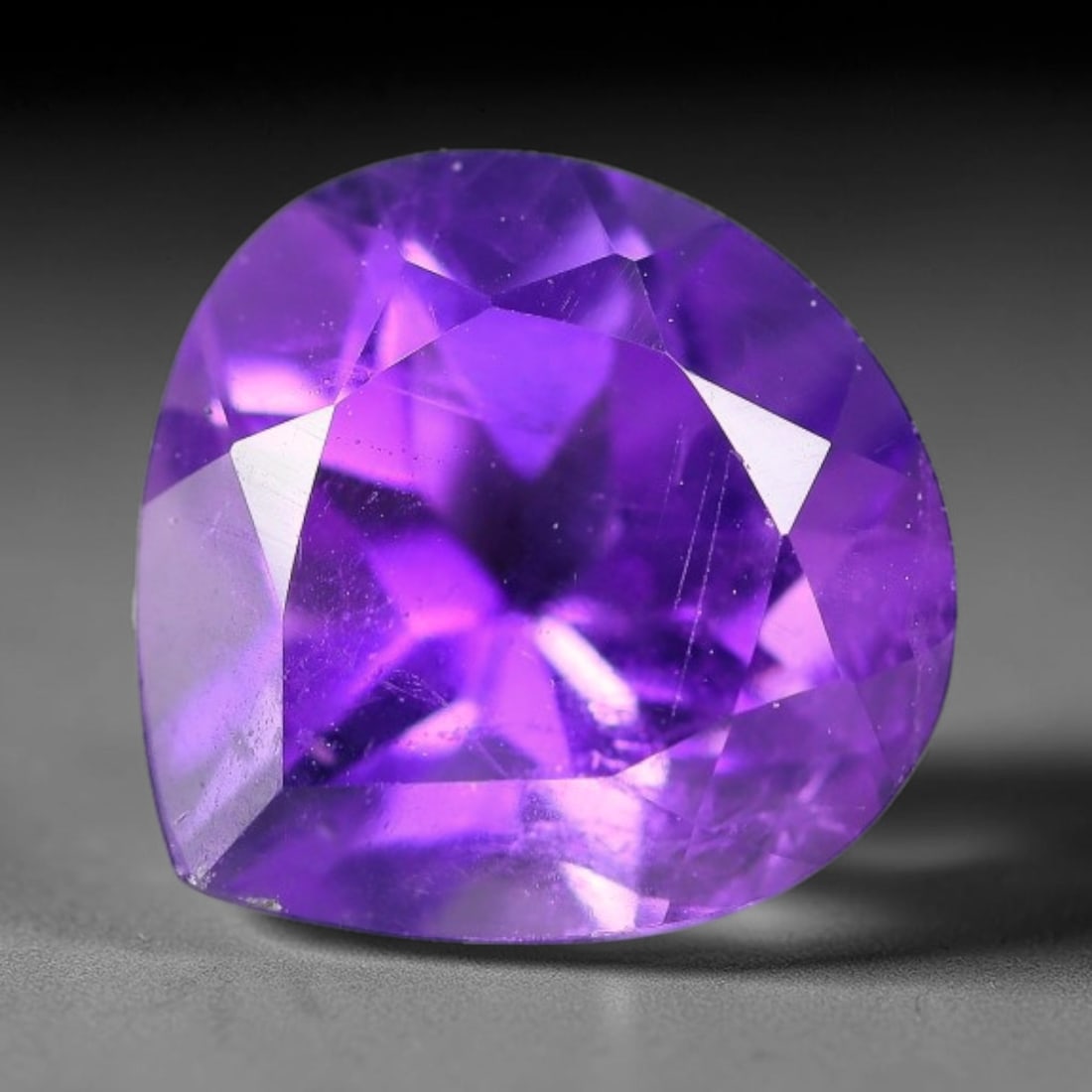 4.38ct Natural Brazilian Purple Amethyst Pear Faceted Gemstone, 63YW: This faceted gemstone is composed of natural Brazilian amethyst, cut in a pear shape with precise faceting to showcase the saturated purple hue. The stone displays natural internal inclusions consiste