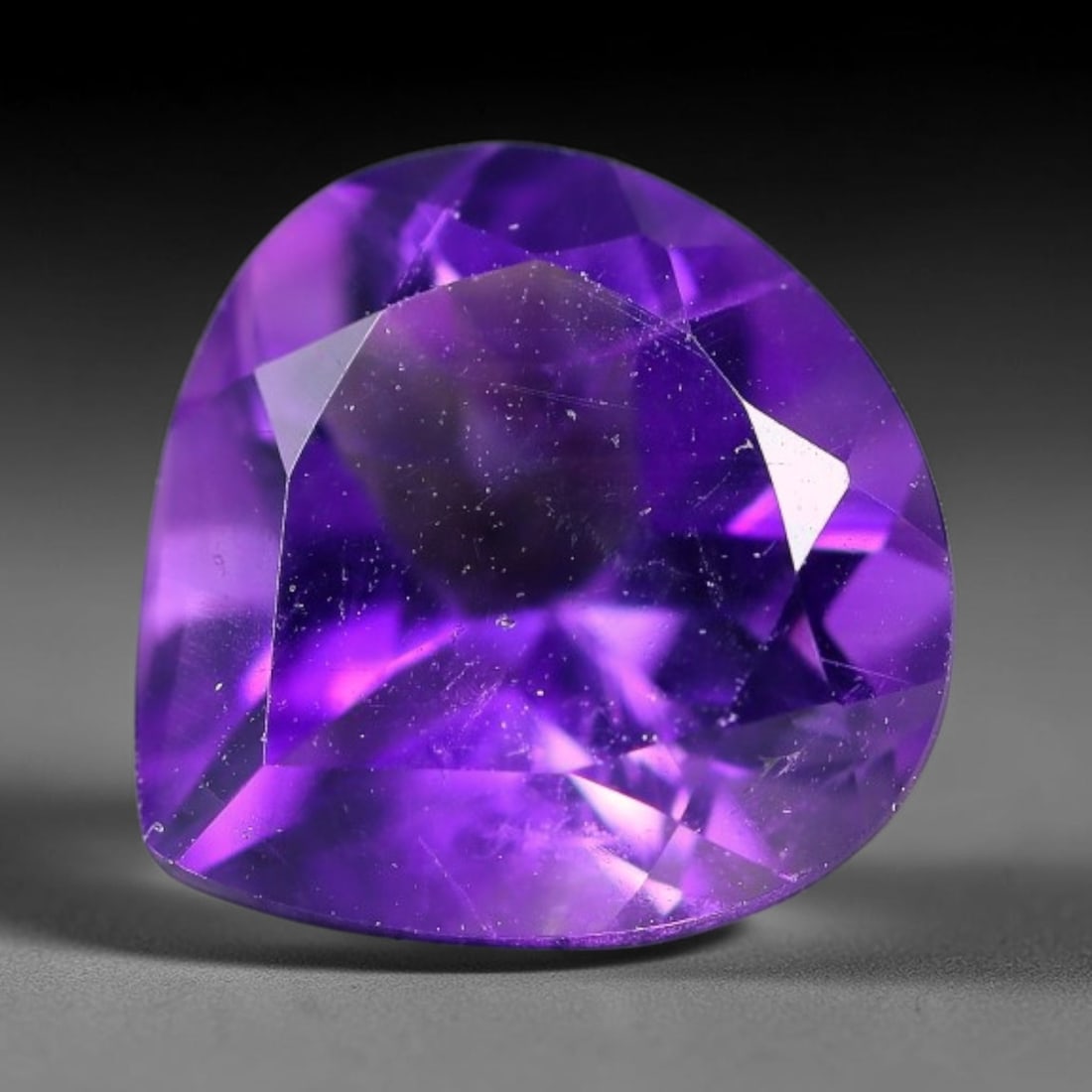 4.41ct Natural Brazilian Purple Amethyst Pear Faceted Gemstone, 60YW: This faceted gemstone is composed of natural Brazilian amethyst, cut in a pear shape with precise faceting to showcase the saturated purple hue. The stone displays natural internal inclusions consiste