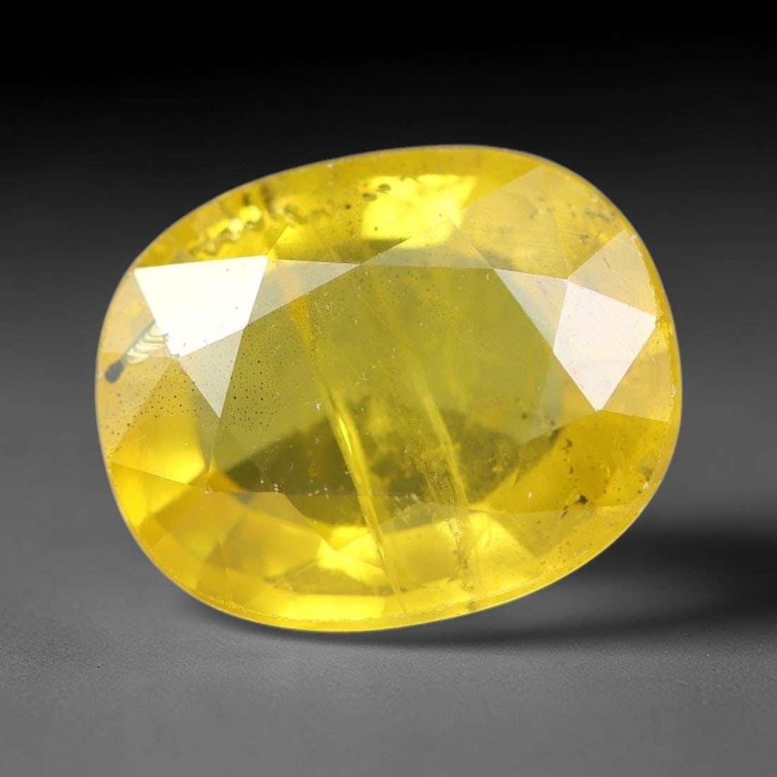 2.03 Carats Natural Yellow Sapphire Oval Faceted Loose Gemstone, 39YW: This natural yellow sapphire features a classic oval brilliant faceted cut, holding consistent warm golden-yellow color throughout the corundum crystal. Fine microscopic mineral specks and faint natur