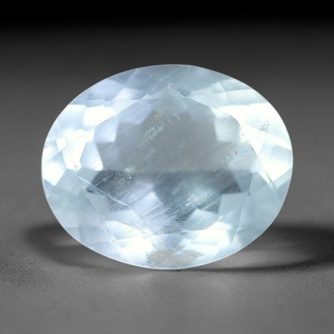 4.08ct Natural Pale Blue Aquamarine Oval Faceted Gemstone, 9YW: This faceted gemstone is natural aquamarine, cut in an oval form with polished facets displaying its soft pale blue hue. Visible natural internal features occur within the crystal, consistent with unt