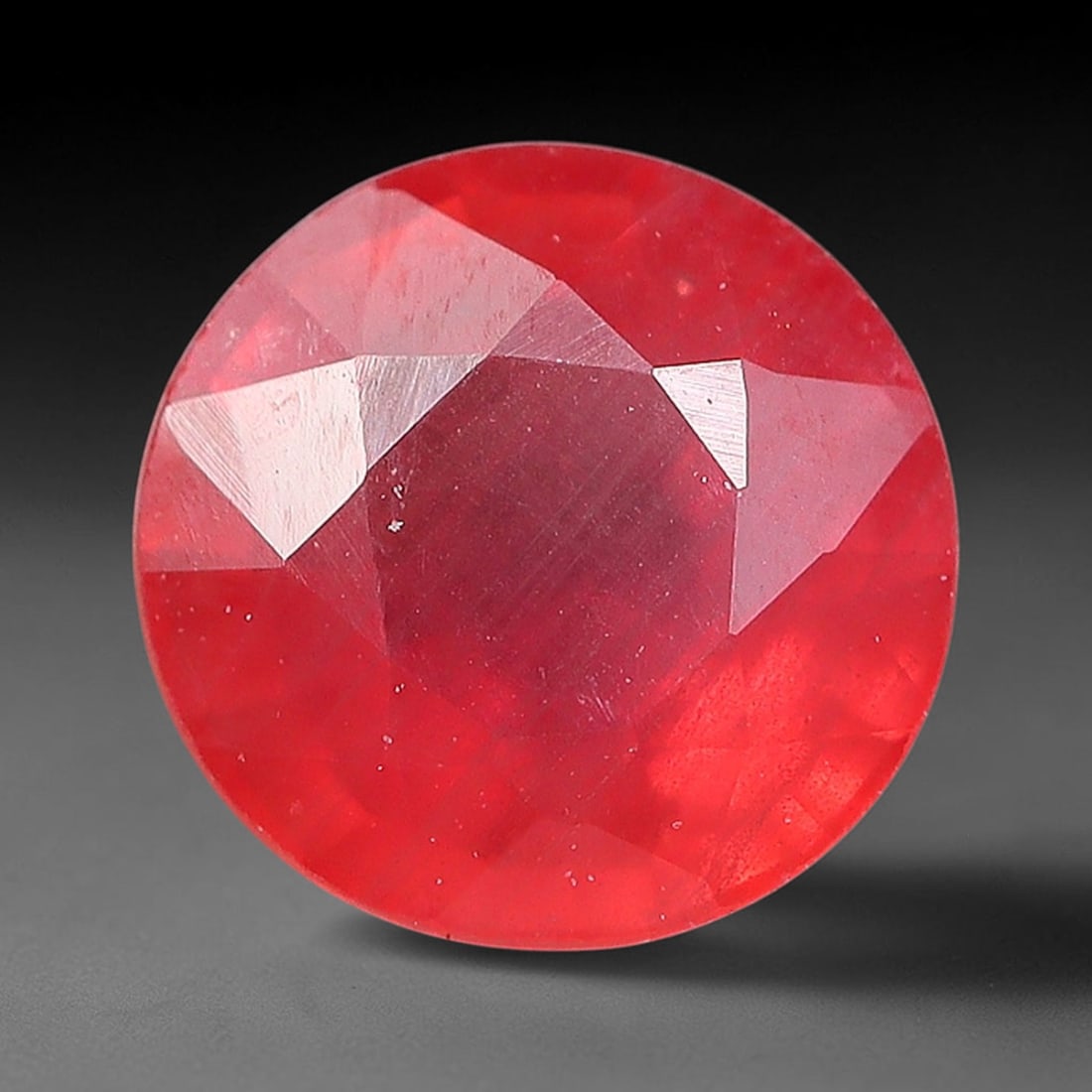 0.84ct Natural Orange Red Sapphire Round Faceted Loose Gemstone, 87YW: This faceted gemstone consists of natural sapphire, cut in a round shape with polished facets that showcase its orange red colouration. Natural internal inclusions and surface characteristics are visi