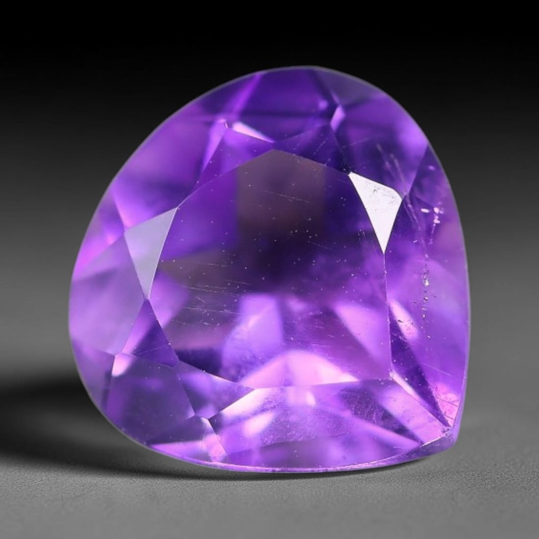 4.07ct Natural Brazilian Purple Amethyst Pear Faceted Gemstone, 62YW: This faceted gemstone is composed of natural Brazilian amethyst, cut in a pear shape with precise faceting to showcase the saturated purple hue. The stone displays natural internal inclusions consiste
