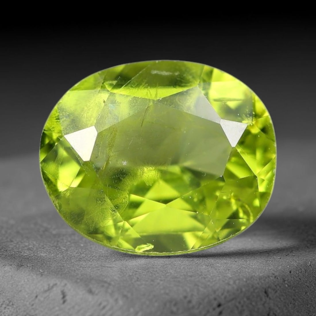 3.21ct Natural Pakistan Green Peridot Oval Faceted Gemstone, 23YW: This faceted gemstone consists of natural Pakistani peridot, fashioned into an oval cut with polished facets that highlight its vivid green body colour. Natural mineral inclusions are visible within t
