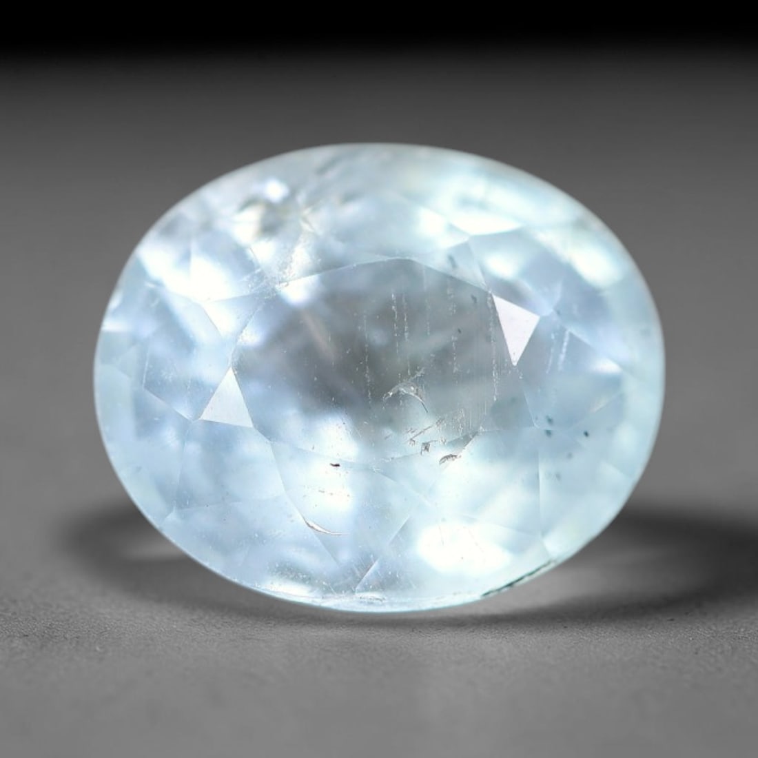 1.27ct Natural Pale Blue Aquamarine Oval Faceted Gemstone, 13YW: This faceted gemstone is natural aquamarine, cut in an oval form with polished facets displaying its soft pale blue hue. Visible natural internal features occur within the crystal, consistent with unt