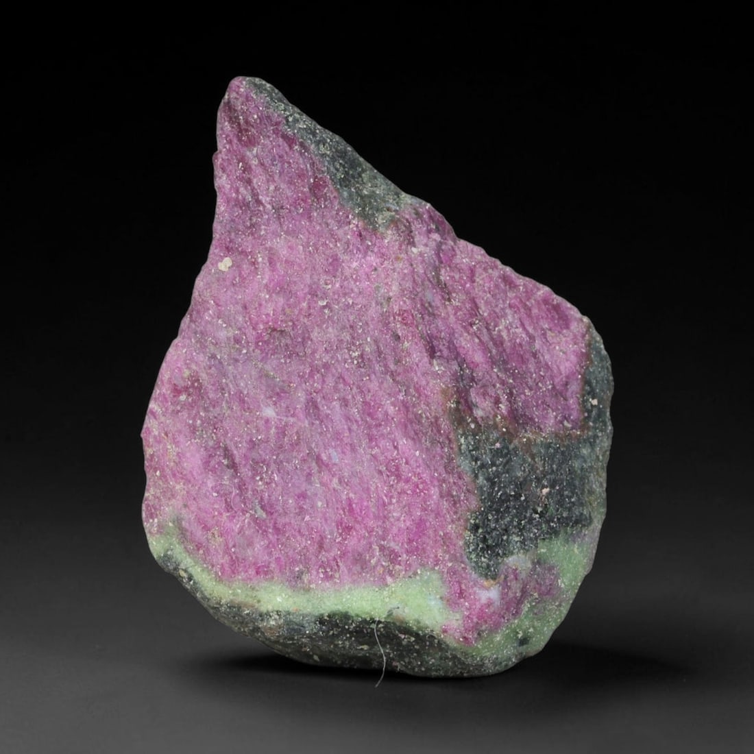 145.11ct Natural Tanzanian Ruby Zoisite Raw Rough Specimen Mineral Stone, 65YT: This unpolished mineral rough is natural ruby zoisite sourced from Tanzania, exhibiting distinct banded mineral segregation of vibrant green zoisite, magenta ruby crystals, and dark hornblende inclusi