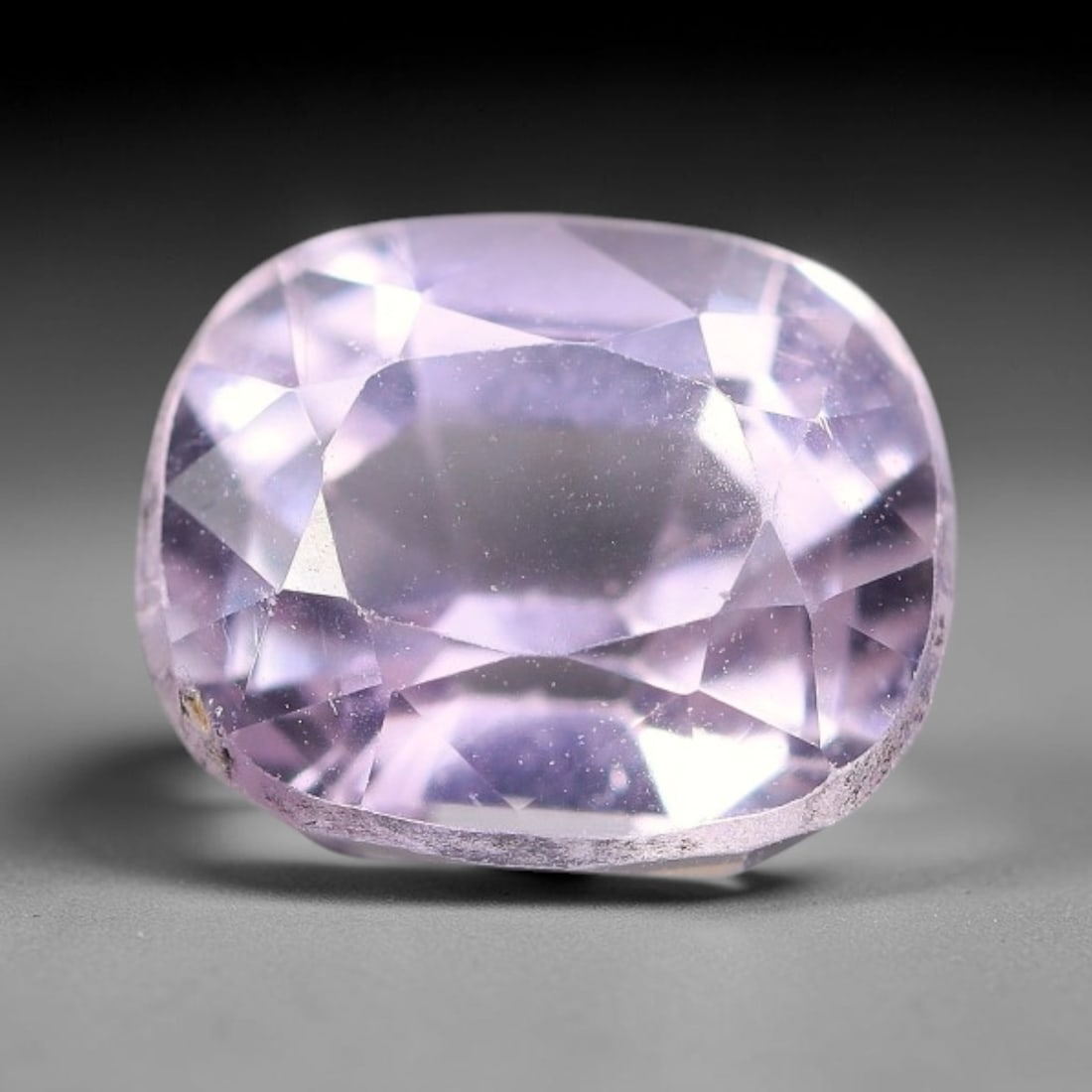 4.09ct Natural Soft Lavender Kunzite Cushion Cut Loose Gemstone, 69TH: This faceted specimen is natural kunzite, fashioned in a cushion cut. The stone displays a translucent soft lavender hue, with fine particulate inclusions distributed throughout the crystal matrix. Mi