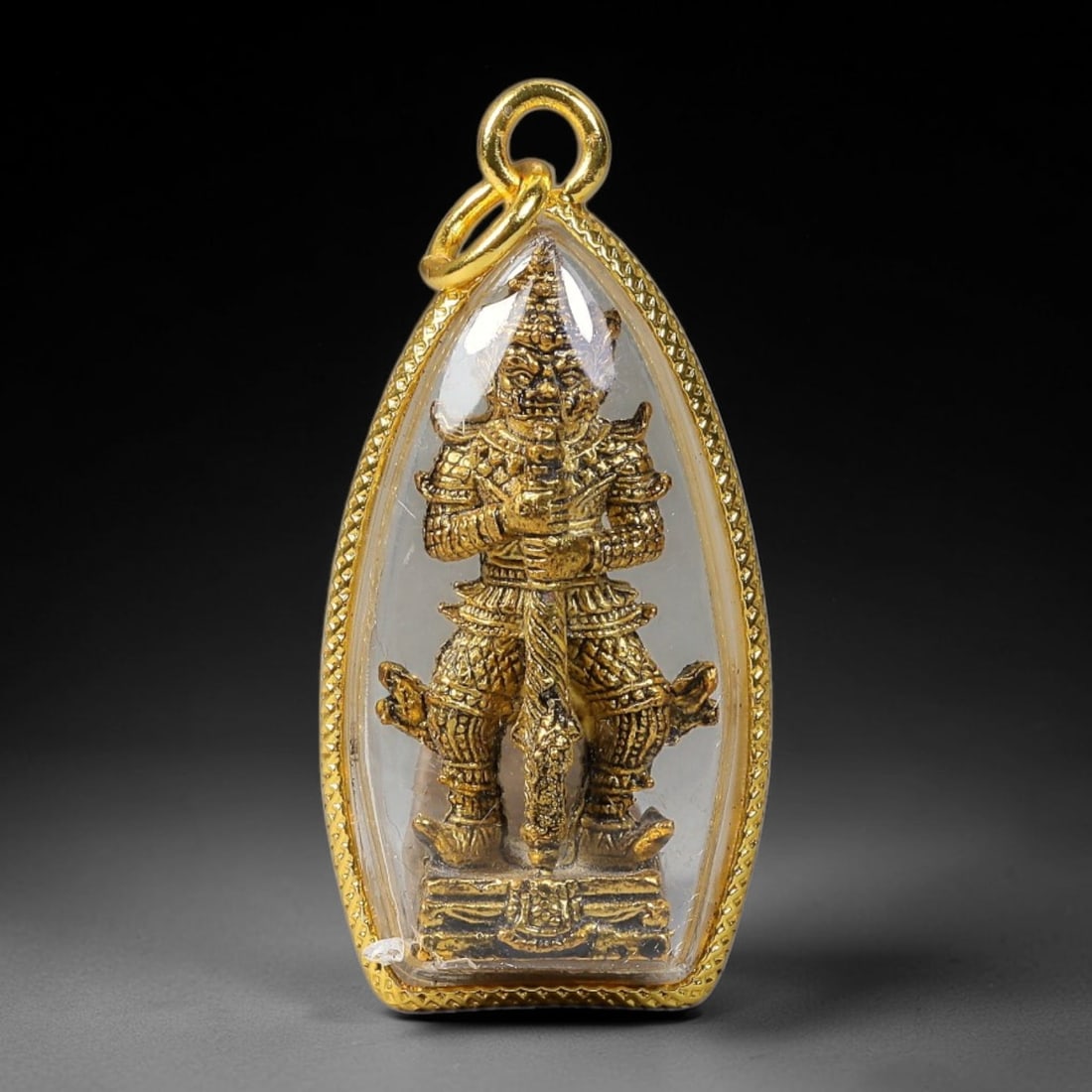 Thai Gold Plated Giant Yak Guardian Amulet Pendant With Clear Protective Casing, 70YY: Teardrop-shaped gold plated textured frame amulet measuring 4.0x2.0cm, fitted with dual gold jump rings for necklace attachment. Encased in transparent clear dome cover to shield the miniature golden 