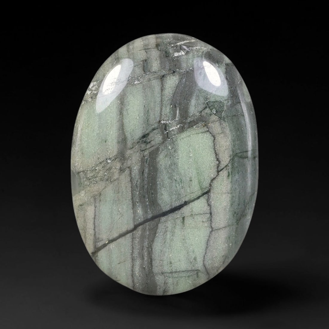 59.29ct Natural Green Banded Jasper Oval Polished Palm Stone, 46TH: This polished specimen is natural green banded jasper, formed as a smooth oval palm stone. The stone displays distinct layered banding in muted sage green and grey tones, crossed by fine dark natural 