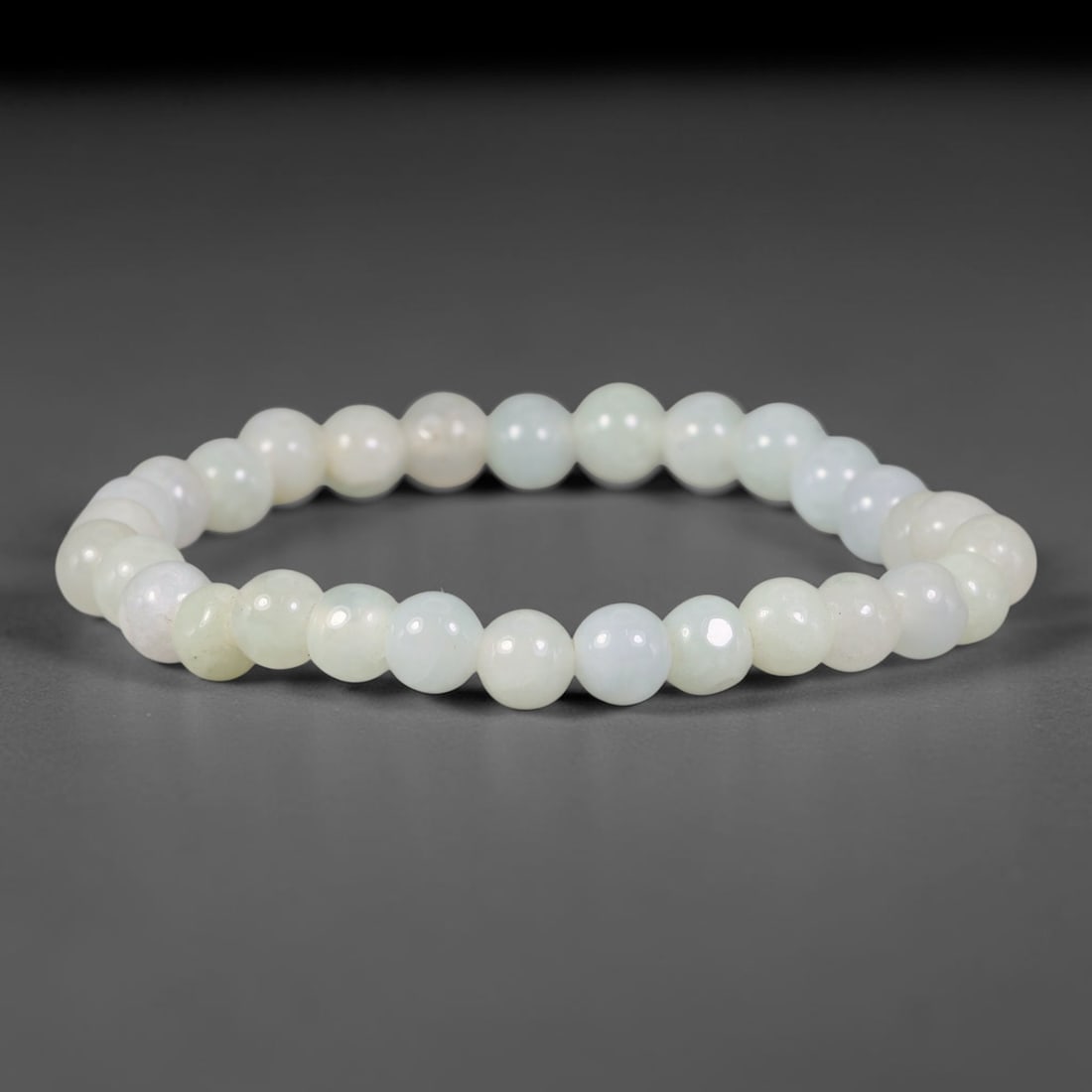 Natural Burmese Type A Pale Cream Celadon Jadeite Jade Bead Bracelet, 48TP: Strung from natural Type A Burmese jadeite, this fine spherical bead bracelet carries a soft pale cream celadon tone with delicate faint natural clouding across the beads. Each bead is smoothly polish