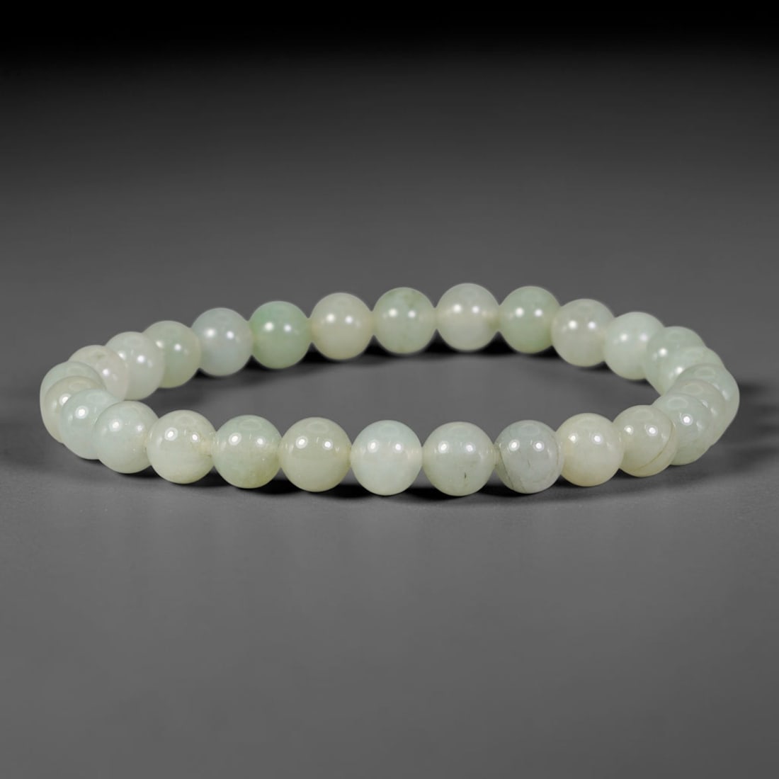 Natural Burmese Type A Pale Lime Celadon Jadeite Jade Bead Bracelet, 35TP: Strung from natural Type A Burmese jadeite, this fine spherical bead bracelet displays a delicate pale lime celadon tone with subtle gentle tonal shifts across the beads. Each bead is smoothly polishe