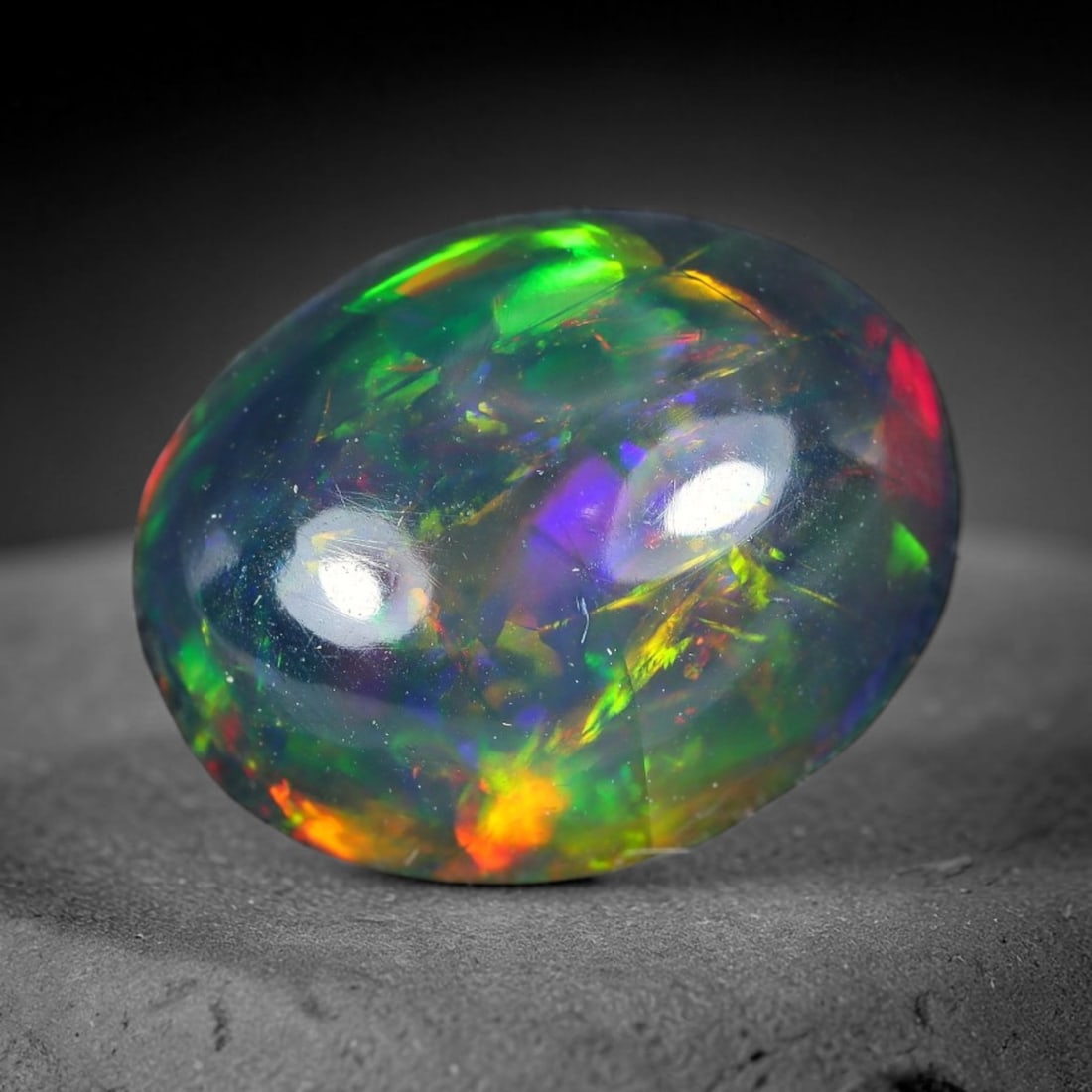 2.26ct Natural Ethiopian Welo Black Smoked Opal Cabochon Loose Gemstone, 89WP: This fully polished Ethiopian Welo opal features a dark smoked base with vivid, sweeping play-of-color shifting across its glossy dome surface, measured at 10.5x8.4x4.9mm. The black smoke treatment de