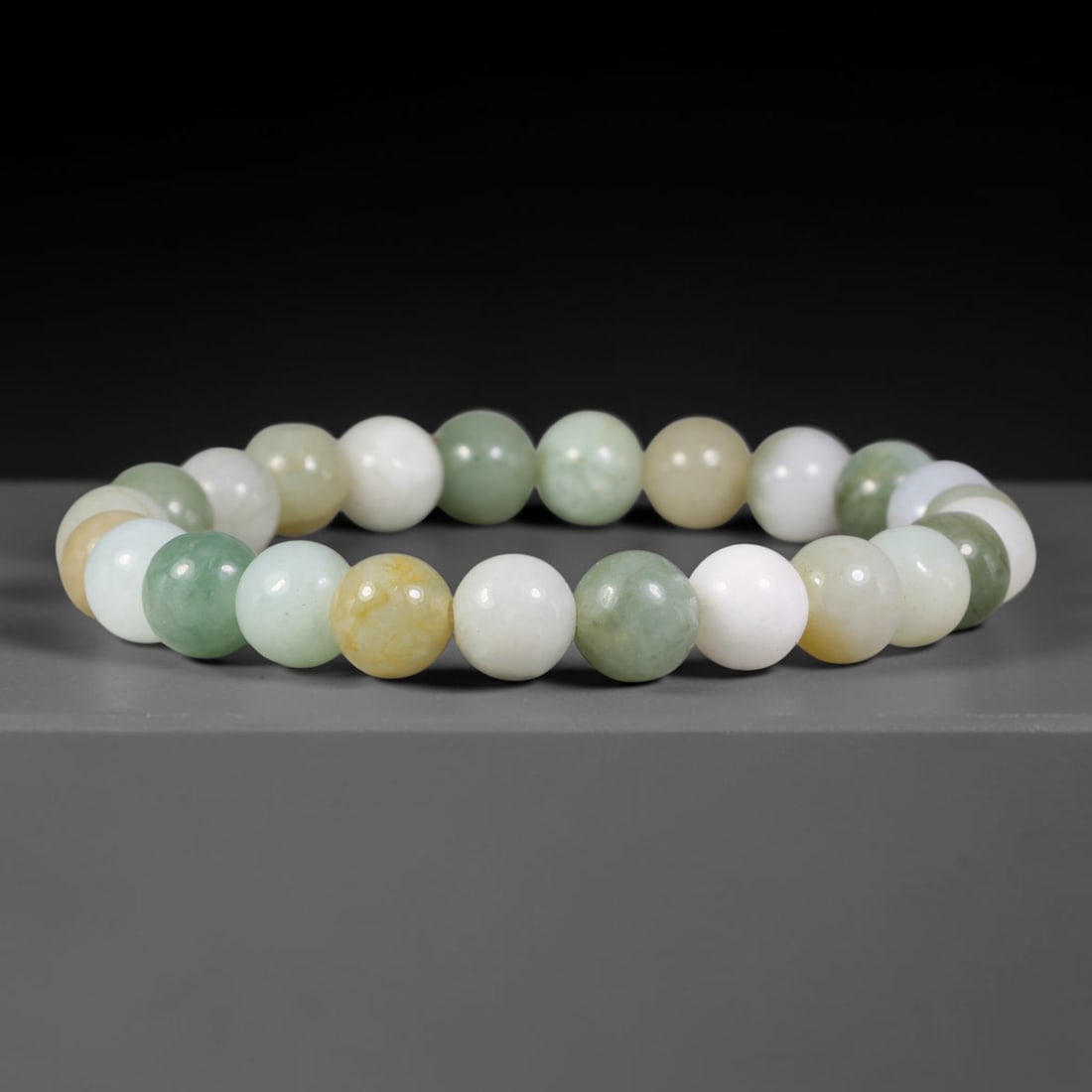 Natural Burmese Type A Multicolour Pastel Jadeite Jade Bead Bracelet, 100TK: Strung from natural Type A Burmese jadeite, this spherical bead bracelet blends soft pastel tones of milky white, pale celadon green and warm honey yellow across the uniformly polished beads. Each bea