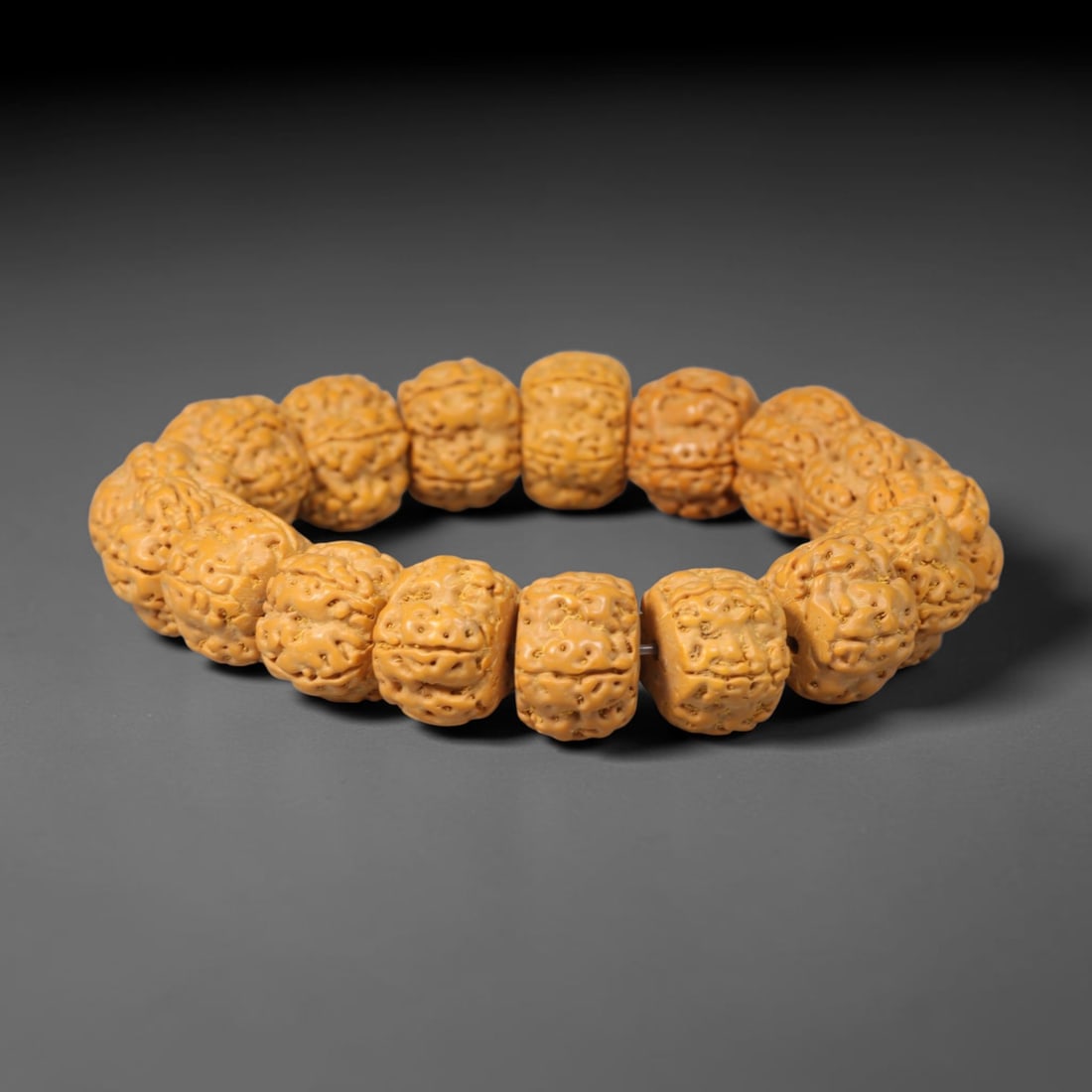 Rudraksha Seed Bracelet - Carved Buddhist Prayer Bead Strand, 61YM: This strand is constructed from naturally textured rudraksha seed beads, shaped into uniform barrel forms with intricate organic fissuring across each surface. The seeds display a consistent pale tan 