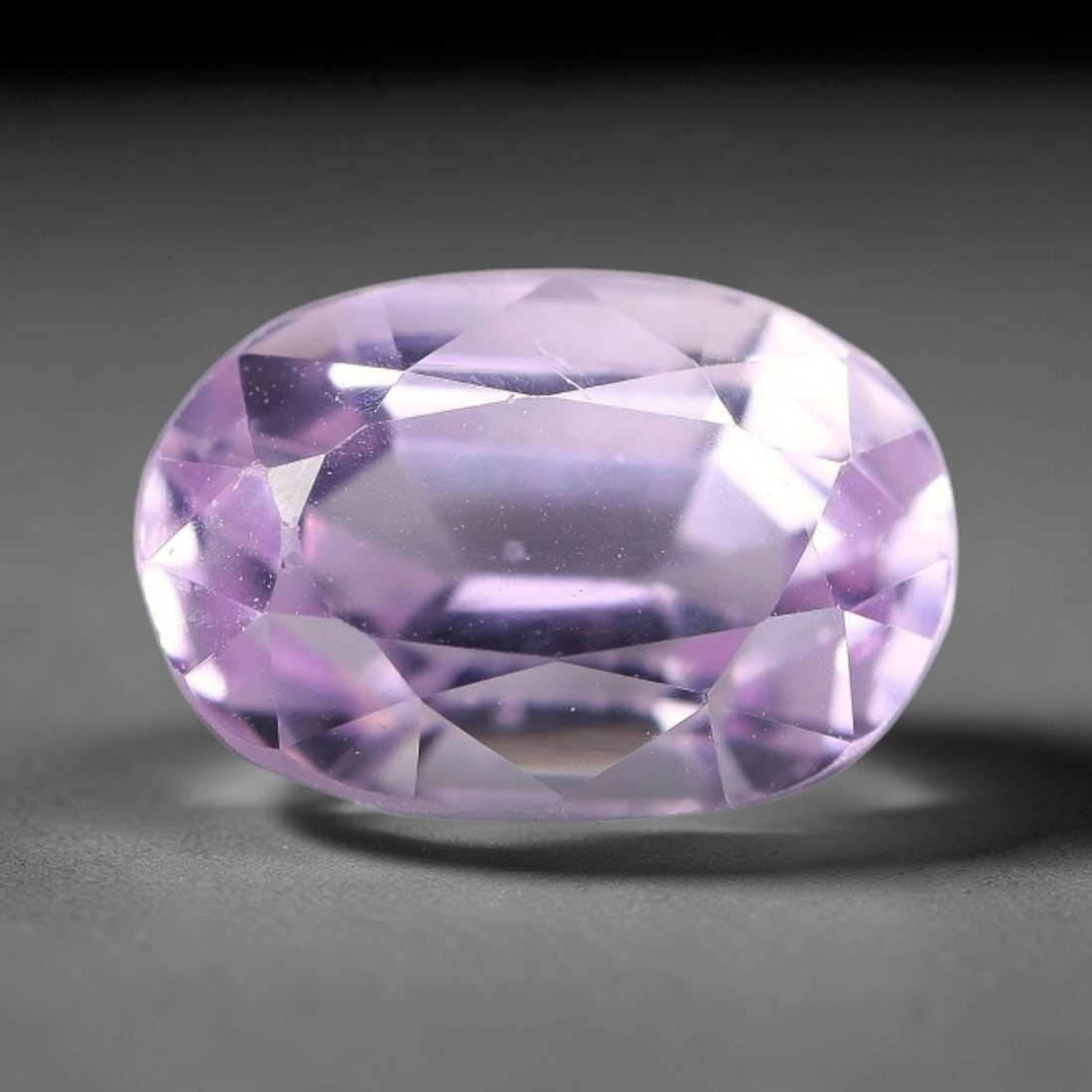 4.73ct Natural Lavender Kunzite Oval Cut Loose Gemstone, 71TH: This faceted specimen is natural kunzite, fashioned in an oval brilliant cut. The stone has a translucent lavender hue, with fine particulate inclusions dispersed throughout the crystal matrix. Faceti