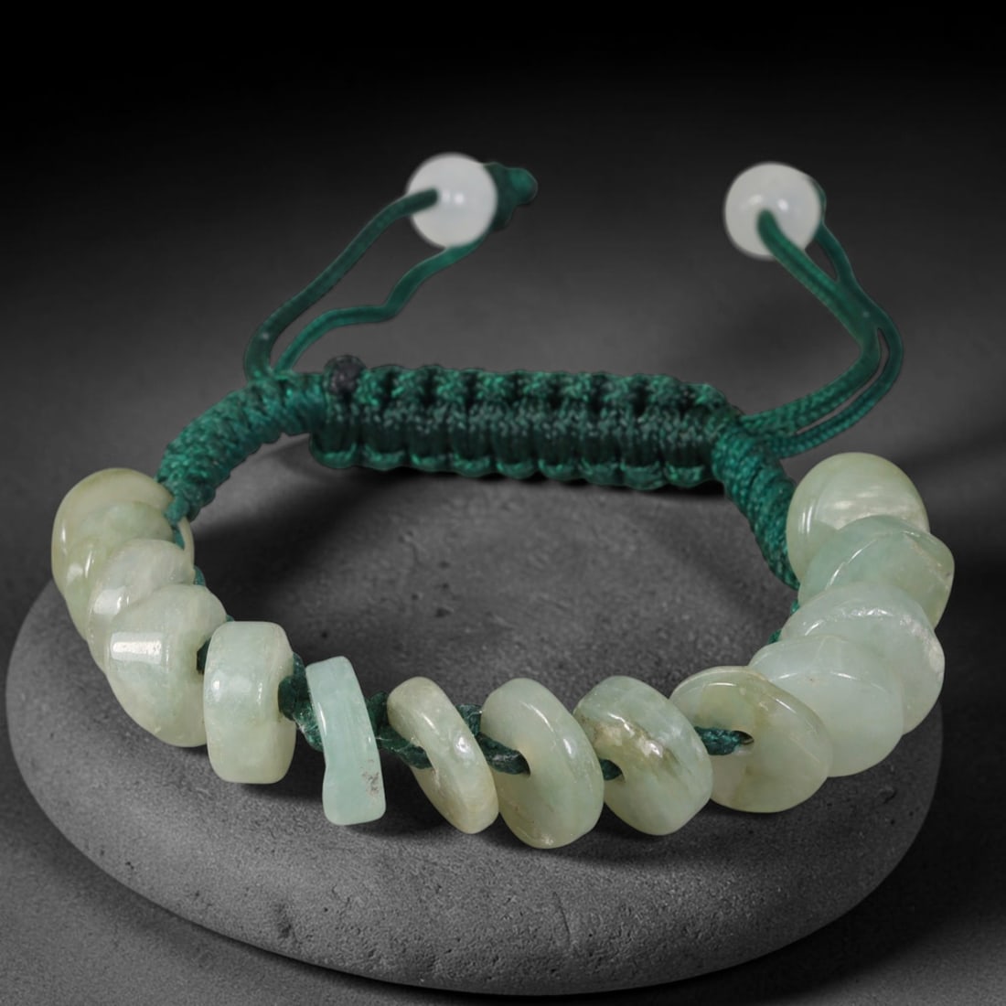 Natural Burmese Type A Pale Celadon Donut Jadeite Adjustable Braided Cord Bracelet, 20TP: Handcrafted adjustable braided dark green cord bracelet, strung with natural Type A Burmese jadeite donut beads in soft pale celadon tone. The flat disc beads carry subtle natural tonal variations and