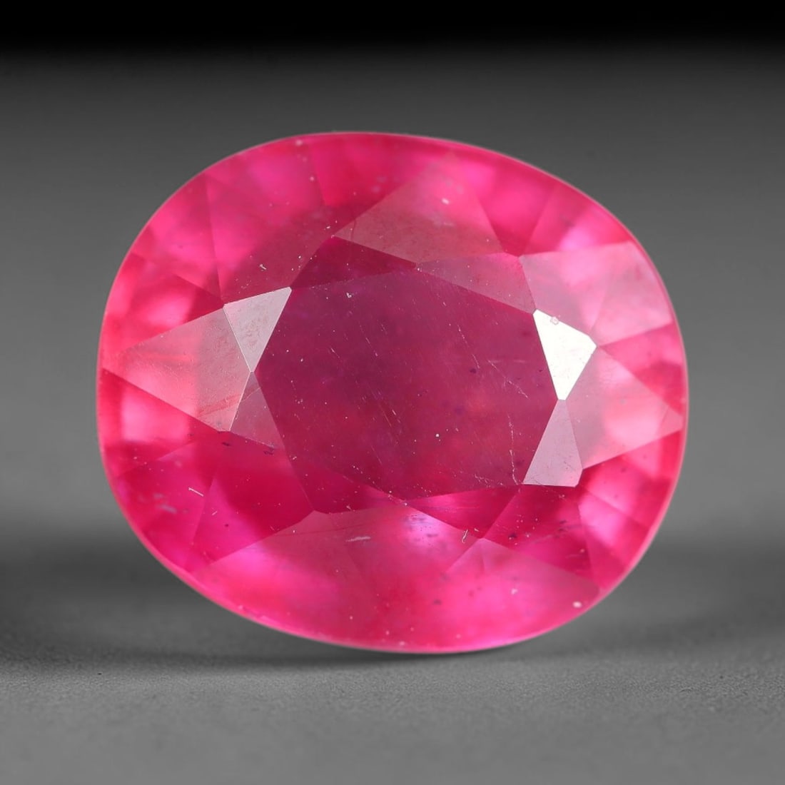 10.09 Carats Natural Mozambique Ruby Oval Faceted Loose Gemstone, 84TH: This natural Mozambique ruby is fashioned with standard oval brilliant faceting, displaying vivid saturated crimson-red hue accompanied by native fine mineral inclusions and subtle trace marks inheren