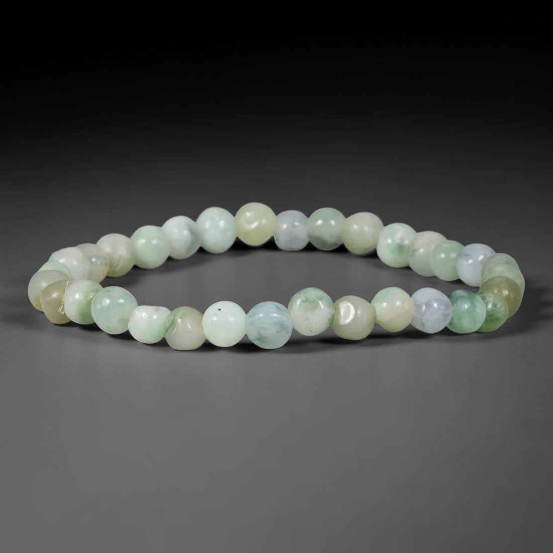 Natural Burmese Type A Pale Celadon Floating Green Round Jadeite Jade Beaded Bracelet, 45TP: Polished elastic strand bracelet hand-strung with genuine untreated Type A Burmese jadeite round beads in soft pale celadon base with delicate floating green and faint bluish wisps. Natural subtle col