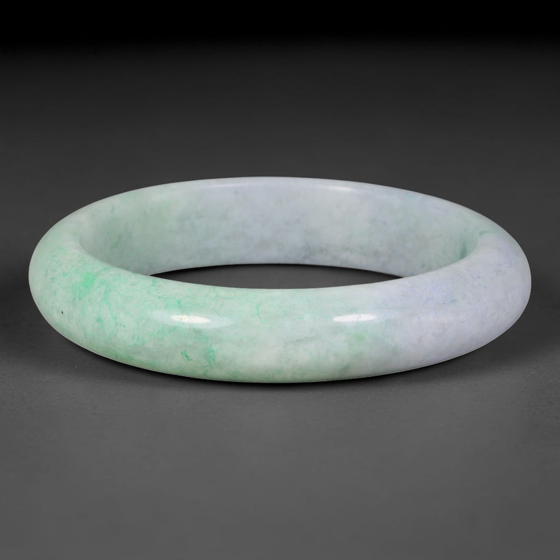 Natural Burmese Type A Jadeite Jade Bangle Bracelet, 7TD: Formed of natural Burmese type-A jadeite, this wide-profile bangle exhibits soft blended tones of pale lavender-white and fresh spring-green, with vibrant green patches concentrated on one section of 