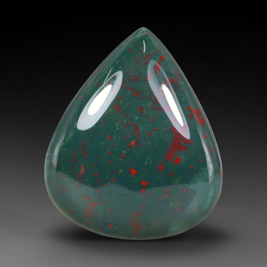 87.99ct Natural Bloodstone Teardrop Polished Cabochon, 42TH: This polished specimen is natural bloodstone, shaped as a smooth teardrop cabochon. Vivid red mineral speckles and flecks scatter across a deep forest green translucent matrix. The surface is uniforml