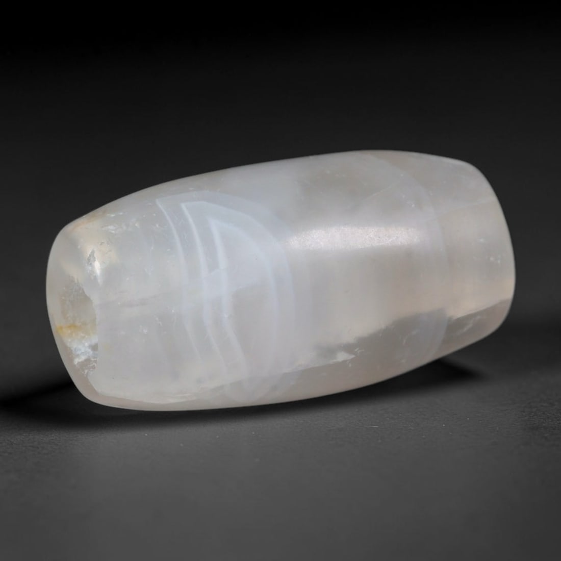 Ancient Sogdian Mini Pale White Layered Chalcedony Slim Barrel Amulet Bead (500-1000 CE), 30XD: This tiny compact slim barrel chalcedony bead was hand-carved by Sogdian Silk Road caravan artisans, crafted as miniature pocket talismans for layering into delicate multi-strand necklaces traded acro