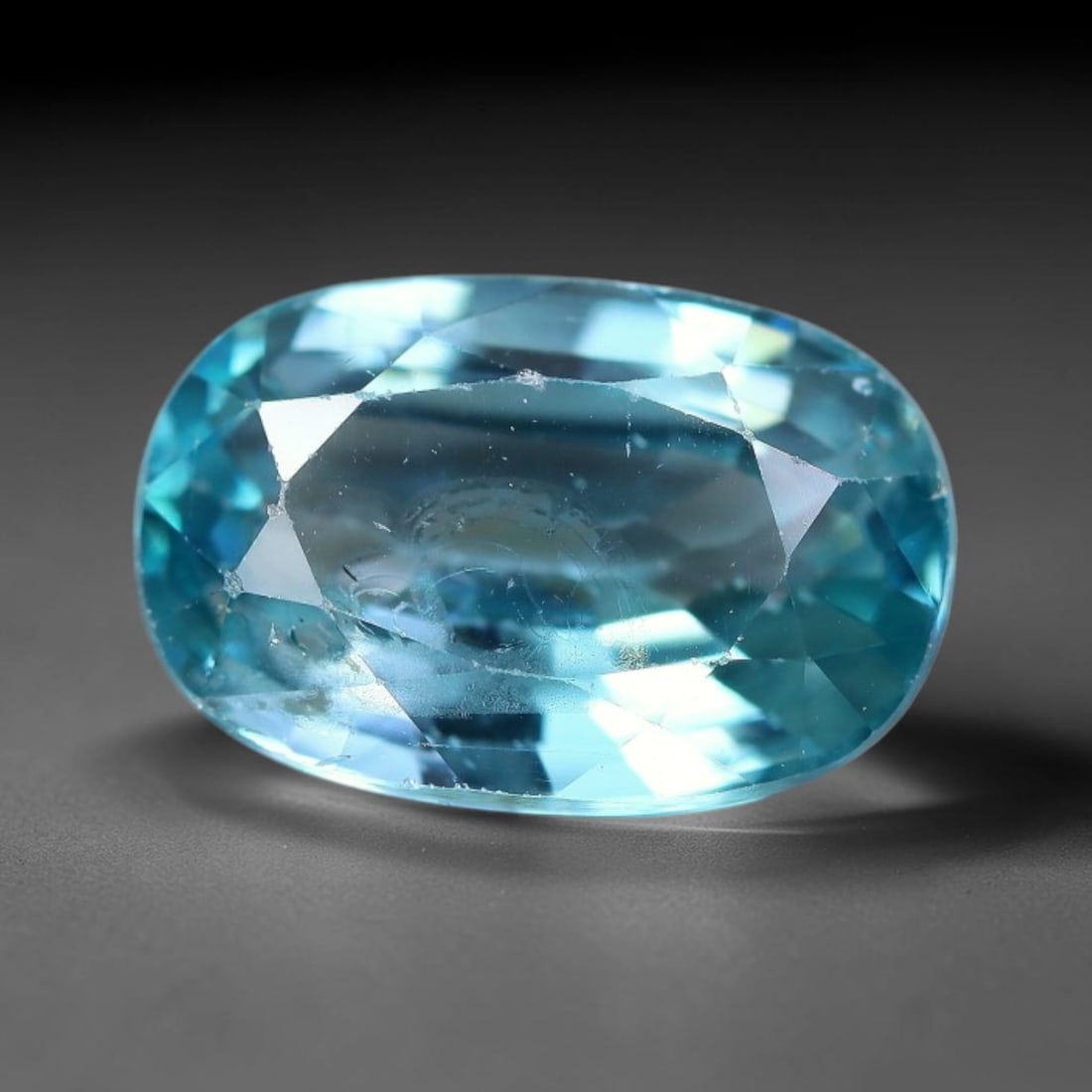 2.91ct Natural Sky Blue Zircon Oval Cut Loose Gemstone, 16TM: This faceted specimen is natural zircon, fashioned in an oval brilliant cut. The stone displays a translucent sky blue hue, with fine internal inclusions visible within the crystal structure. Faceting