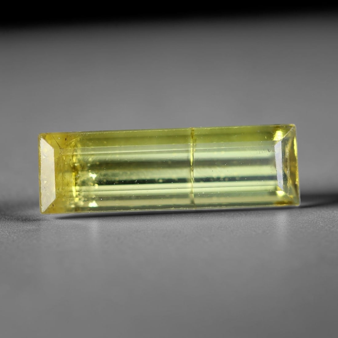 1.65 Carats Natural Lemon Yellow Long Emerald Cut Tourmaline Loose Faceted Gemstone, 96XZ: Natural translucent lemon yellow elbaite tourmaline expertly fashioned into an elongated emerald step-cut loose gemstone, featuring clean linear step facets that deliver sleek, even light transmission