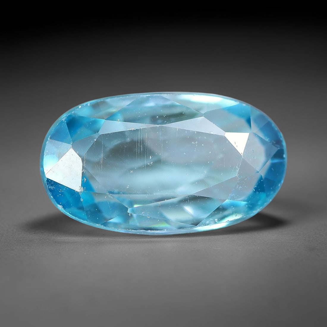3.40ct Natural Sky Blue Zircon Oval Cut Loose Gemstone, 19TM: This faceted specimen is natural zircon, fashioned in an oval brilliant cut. The stone displays a translucent sky blue hue, with fine internal inclusions visible within the crystal structure. Faceting