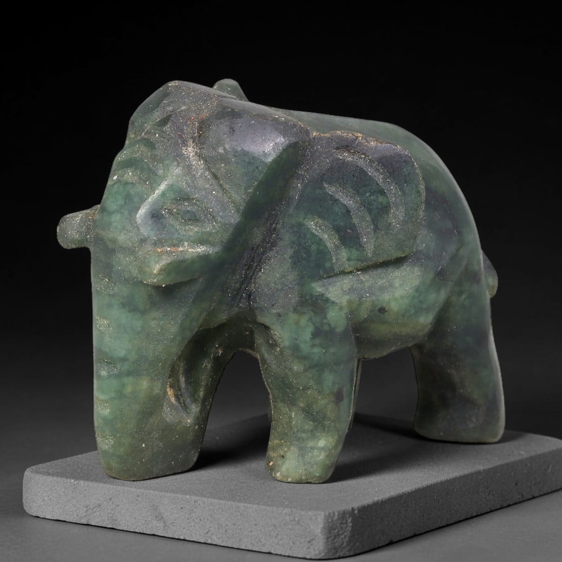 Natural Burmese Type A Dark Mottled Green Jadeite Jade Elephant Carving, 3TC: Hand-carved from natural Burmese Type A jadeite, this elephant figurine measures 47x29mm. It displays rich dark mottled green tones with natural inclusions, veining and subtle lighter green patches ac