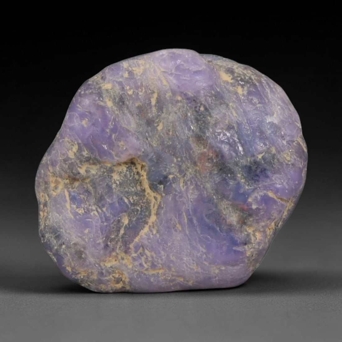 19ct Natural Unheated Sri Lankan Purplish Blue Sapphire Rough, 55YQ: This natural corundum rough is an unheated purplish blue sapphire sourced from Sri Lankan alluvial gem deposits, featuring an irregular natural native form with residual pale yellow-brown mineral matr