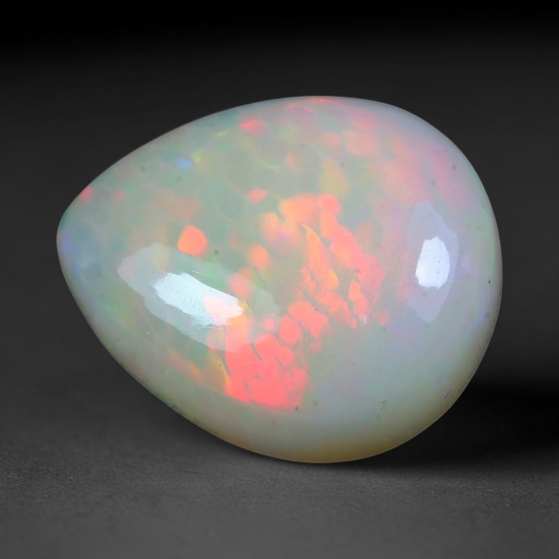 10.54ct Natural Ethiopian Welo Solid Opal Pear Cabochon Loose Gemstone, 19TG: Solid opal cabochon sourced from Ethiopia's Welo opal mining fields, polished into a wide rounded pear domed cut with flawless high-gloss reflective finish. The translucent milky base features strikin
