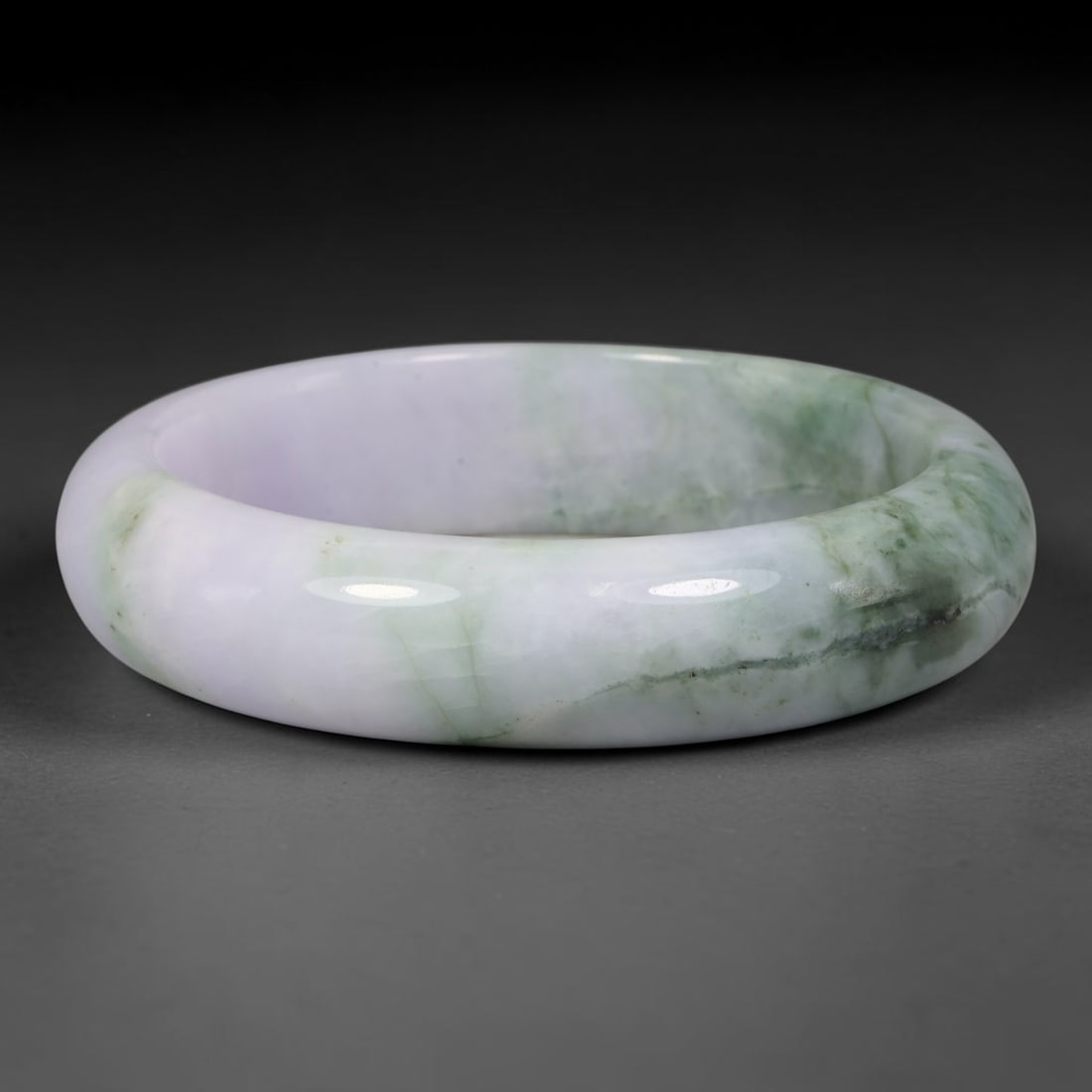 Natural Burmese Type A Lavender Floating Green Jadeite Jade Bangle Bracelet, 62TD: Polished from natural Burmese jadeite, this solid bangle features a soft pale lavender base transitioning into flowing bands of floating green veining along one side of the matrix. Formed in a traditi