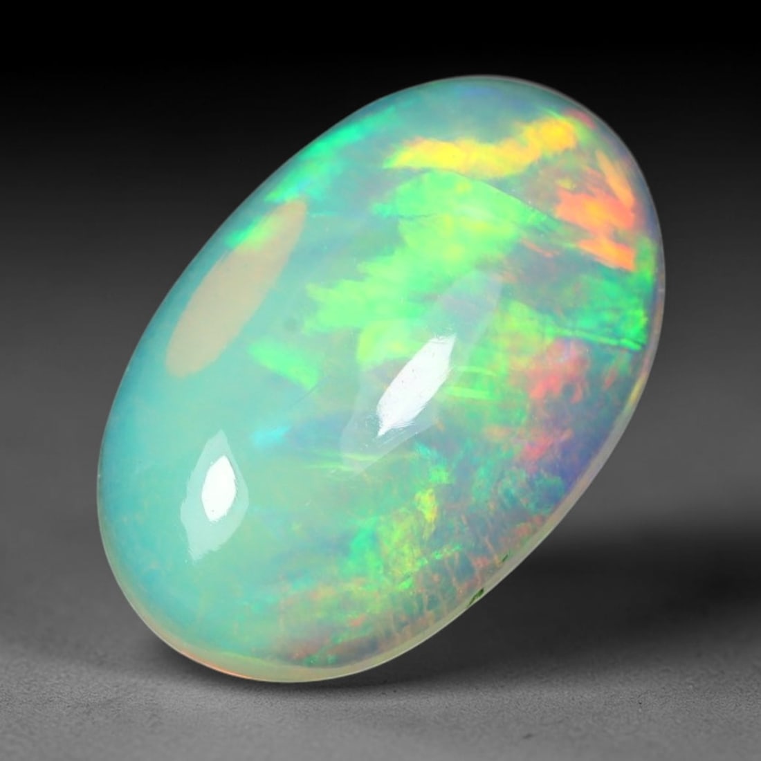 2.05ct Natural Ethiopian Welo Solid Opal Oval Cabochon Loose Gemstone, 48TG: Solid opal cabochon mined from Ethiopia's Welo opal deposits, polished into a smooth elongated oval dome with high reflective gloss. The translucent pale milky base hosts broad shifting play-of-color 