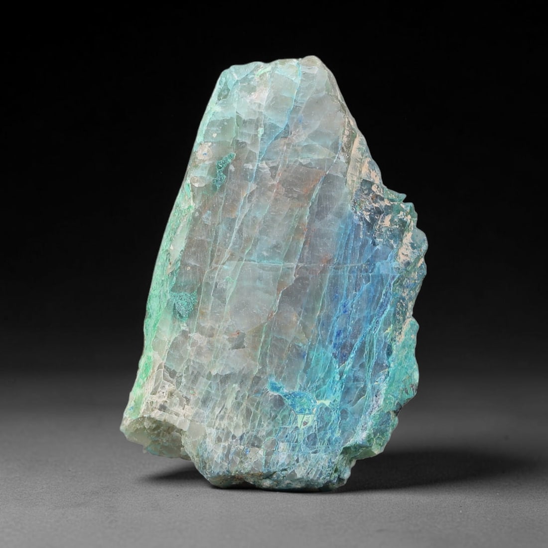 60.29ct Natural Peruvian Chrysocolla Polished Slab Rough, 91YS: This partial-polished chrysocolla slab features blended mineral matrix with smooth refined face and unaltered natural rugged edge across its 36x23x8mm elongated form, translucent mineral layers hold s