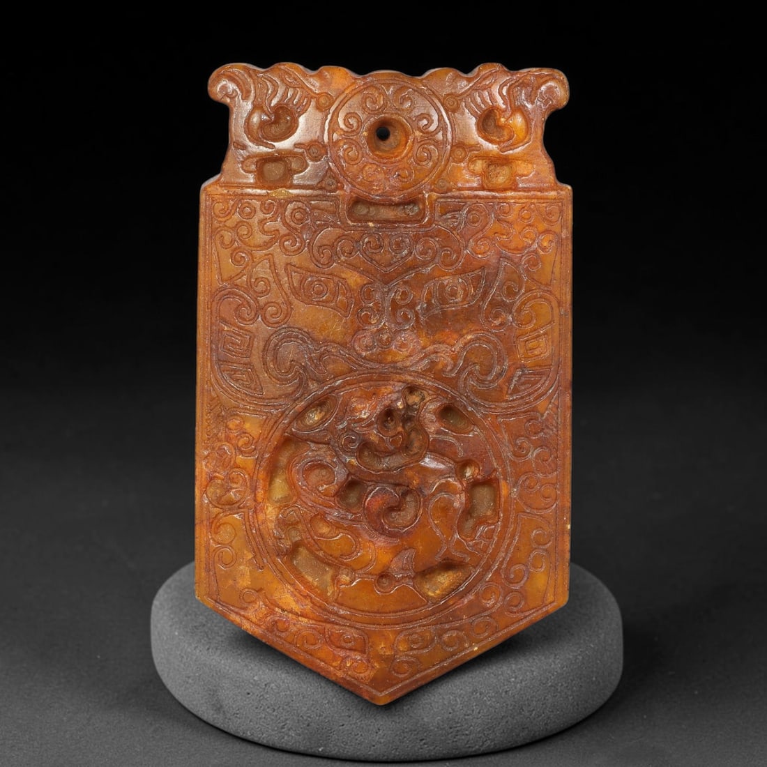 A Chinese Carved Reddish-Brown Jade Stone Plaque Pendant, 95YF: Rectangular shield-shaped jade plaque pendant in rich reddish-brown tone. The obverse is densely decorated with intricate relief and incised ornamentation, including scrolling patterns, stylized decor