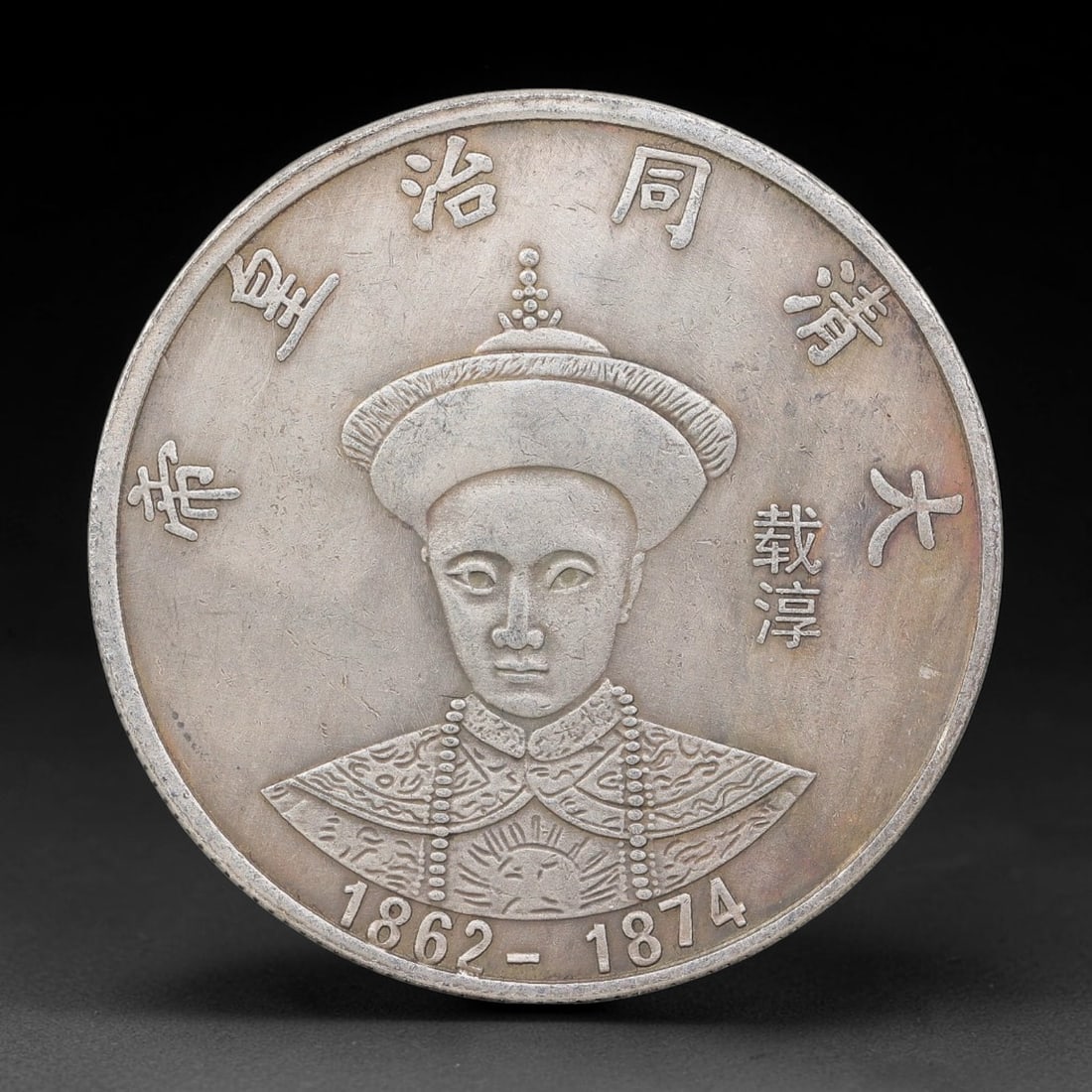 A Chinese Metal Commemorative Coin - Tongzhi Emperor Dragon Medallion, 60ZQ: Cast base-metal medallion with double-sided relief ornamentation. The obverse holds a bust portrait of the Tongzhi Emperor in Qing imperial ceremonial headdress and ornate court robes, surrounded by m