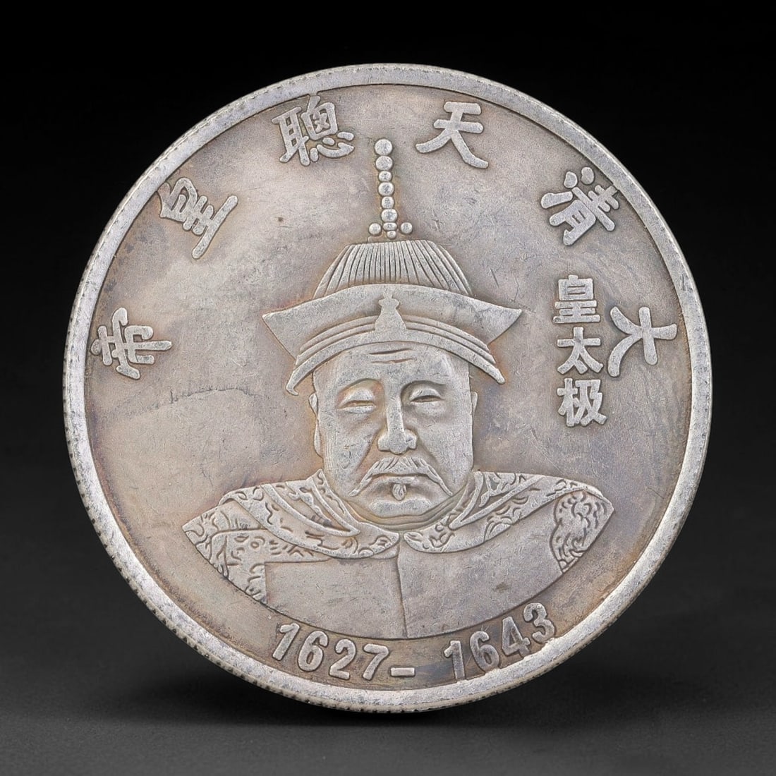 A Chinese Metal Commemorative Coin - Huang Taiji Emperor Dragon Medallion, 57ZQ: Cast base-metal medallion with double-sided relief ornamentation. The obverse features a bust portrait of Huang Taiji in Qing imperial ceremonial headdress and court robes, encircled by moulded Chines