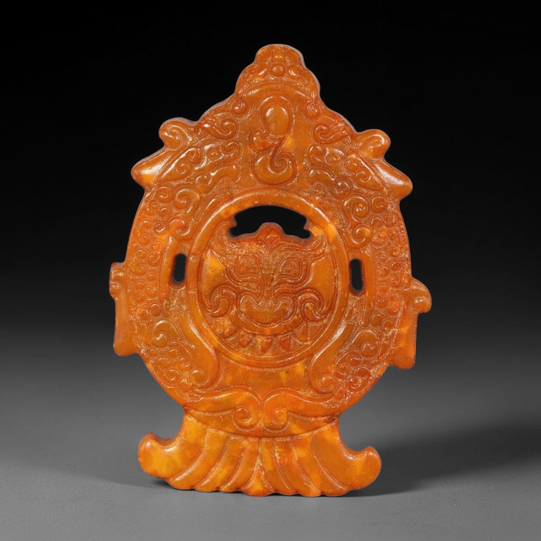A Chinese Open-Work Carved Orange-Reddish Jade Stone Mythical Beast-Face Pendant, 99YF: Elaborate open-work jade pendant with ornate asymmetrical outline. Front side displays fine incised and relief carving featuring a central mythical beast-face motif surrounded by scrolling patterns an