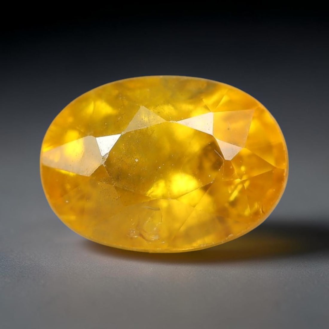 1.30 Carats Natural Yellow Sapphire Oval Faceted Loose Gemstone, 70TT: This natural yellow sapphire features a classic oval brilliant faceted cut, holding consistent warm golden-yellow color throughout the corundum crystal. Fine microscopic mineral specks and faint natur