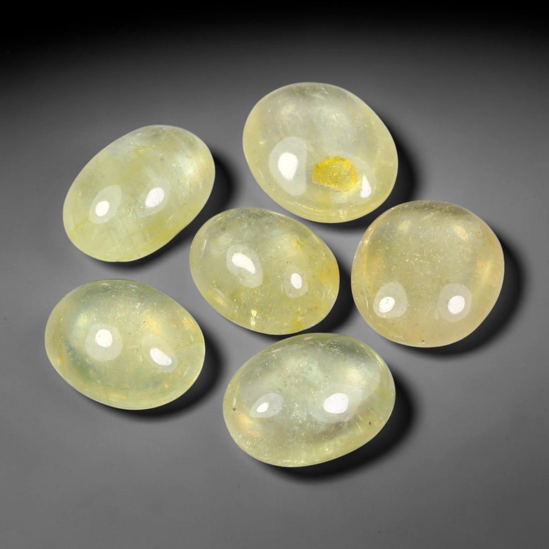 14.80ct Natural Yellow Sapphire Oval Cabochon Loose Gemstone Parcel, 69YW: This parcel oval cabochon natural yellow sapphires with each stone measuring 9.6x7.9x3.1mm. The gemstones display soft pale yellow colouration with natural internal inclusions; stones are fissure fill
