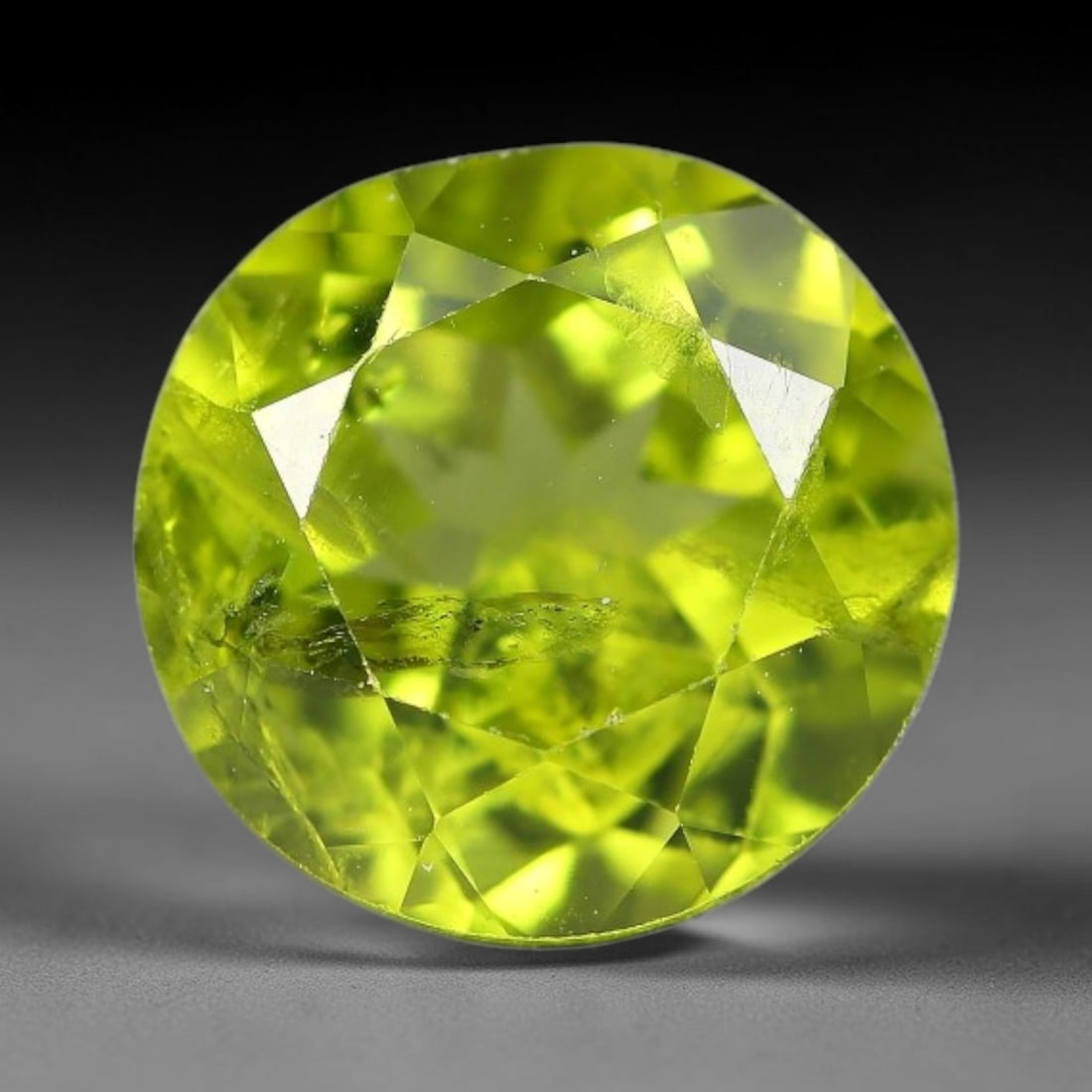 3.73ct Natural Pakistan Green Peridot Round Faceted Gemstone, 22YW: This faceted gemstone consists of natural Pakistani peridot, fashioned into an round cut with polished facets that highlight its vivid green body colour. Natural mineral inclusions are visible within 