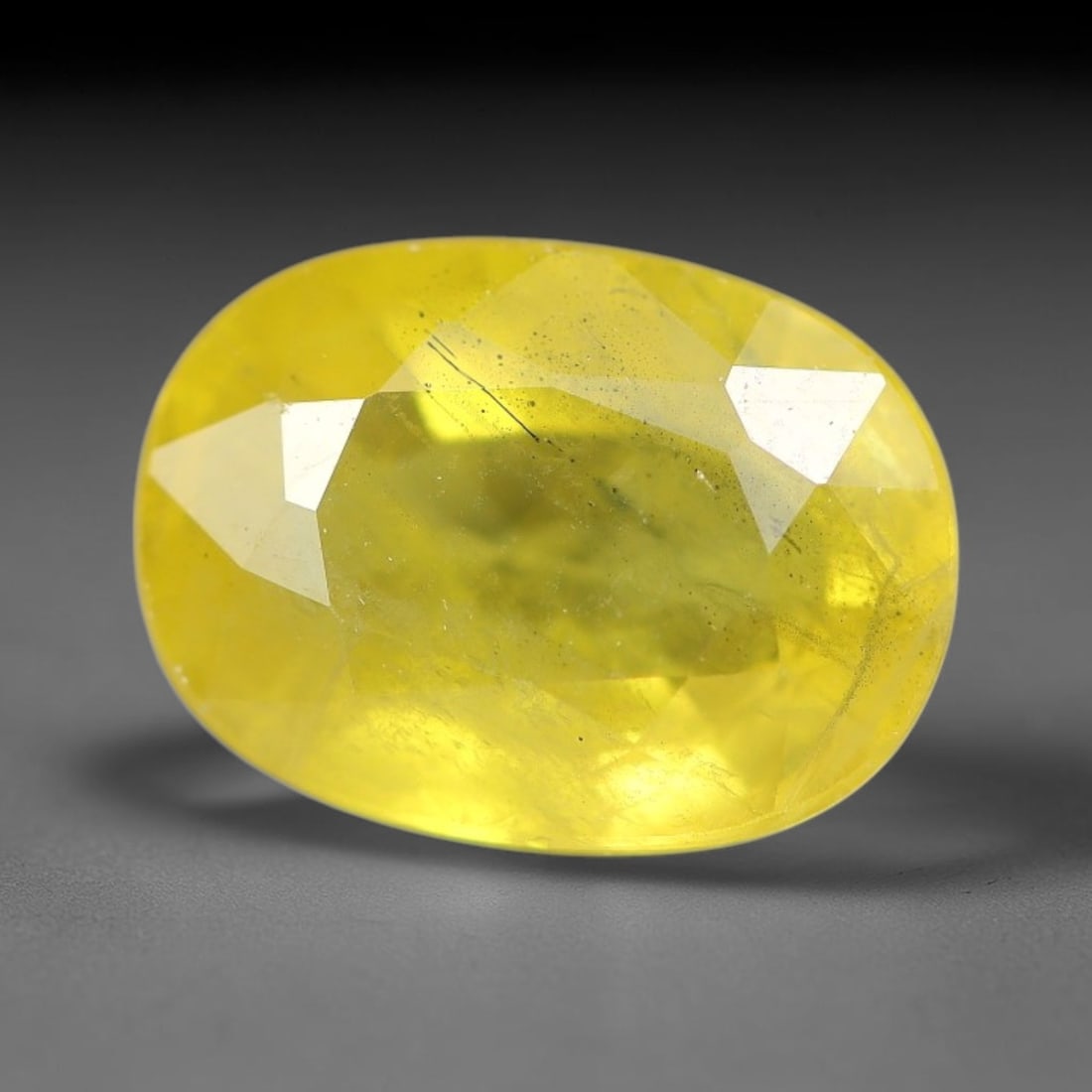 2.47 Carats Natural Yellow Sapphire Oval Faceted Loose Gemstone, 40YW: This natural yellow sapphire features a classic oval brilliant faceted cut, holding consistent warm golden-yellow color throughout the corundum crystal. Fine microscopic mineral specks and faint natur