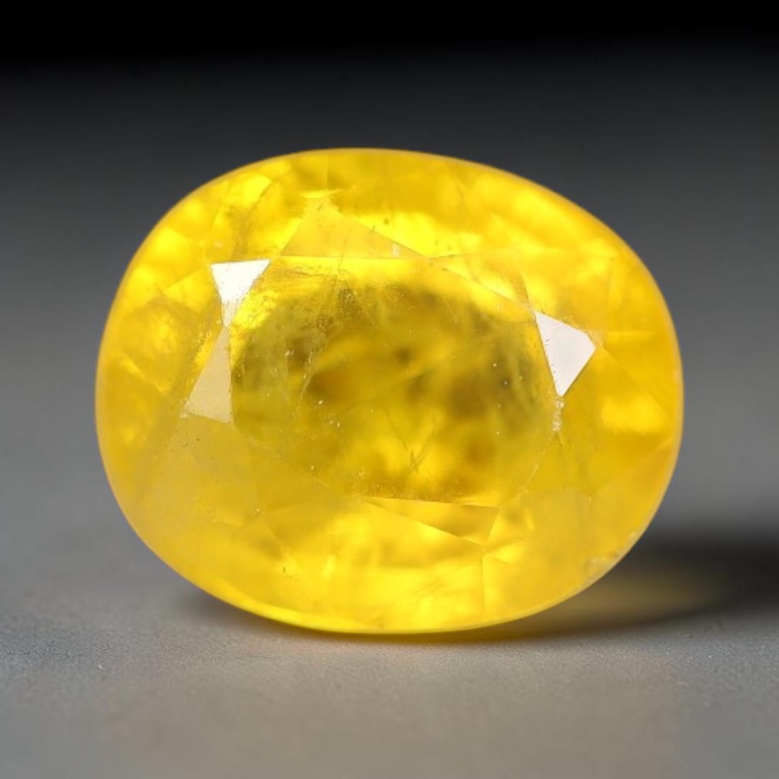 1.22 Carats Natural Yellow Sapphire Oval Faceted Loose Gemstone, 53TT: This natural yellow sapphire features a classic oval brilliant faceted cut, holding consistent warm golden-yellow color throughout the corundum crystal. Fine microscopic mineral specks and faint natur