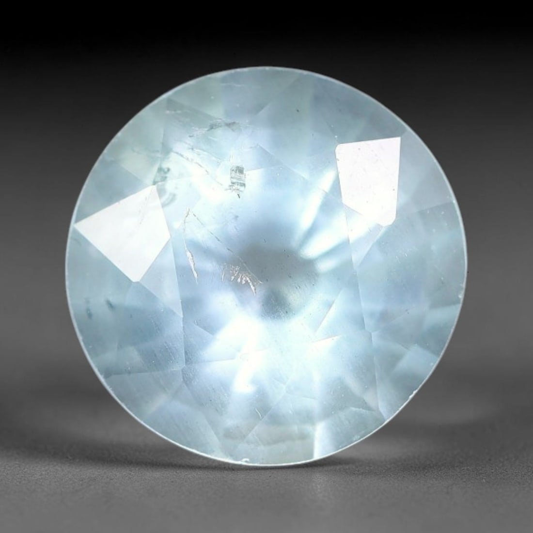 3.19ct Natural Light Blue Aquamarine Round Cut Loose Gemstone, 8YW: This faceted aquamarine specimen exhibits soft pale blue colouration with faint natural internal fractures and subtle mineral inclusions within the transparent beryl crystal. The round brilliant cut f