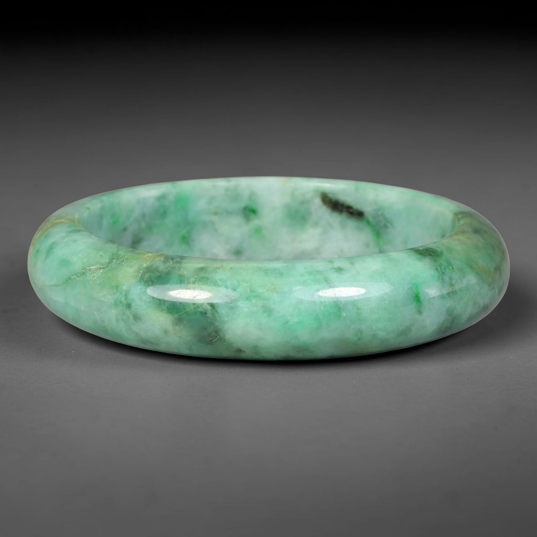 Natural Burmese Type A Moss Floating Green Jadeite Jade Bangle Bracelet, 59TD: Polished jadeite bangle showcasing soft pale base blended with vivid mossy floating green patches and natural dark mineral markings. Inner dimension 58.4x14.8mm, substantial rounded band with smooth g