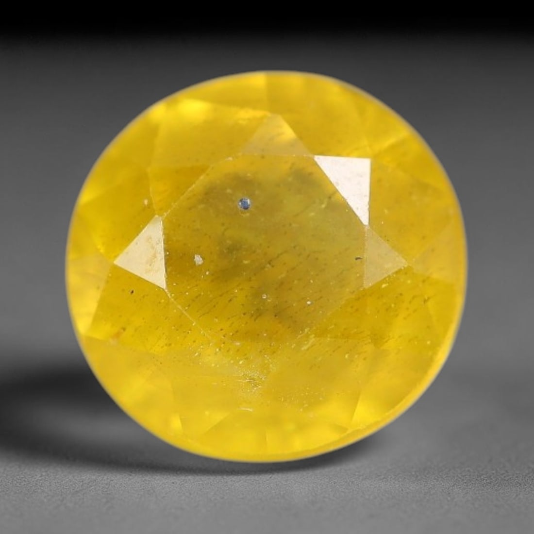 1.67 Carats Natural Yellow Sapphire Round Faceted Loose Gemstone, 45TT: This natural yellow sapphire features a classic round brilliant faceted cut, holding consistent warm golden-yellow color throughout the corundum crystal. Fine microscopic mineral specks and faint natu
