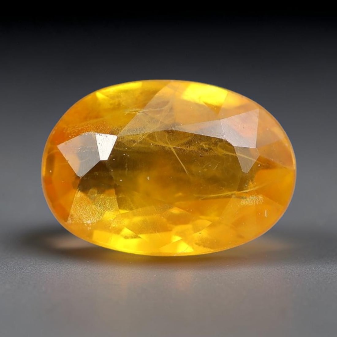 0.83 Carats Natural Yellow Sapphire Oval Faceted Loose Gemstone, 50TT: This natural yellow sapphire features a classic oval brilliant faceted cut, holding consistent warm golden-yellow color throughout the corundum crystal. Fine microscopic mineral specks and faint natur