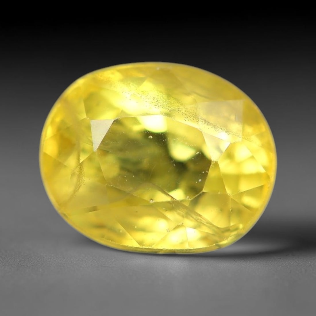2.02 Carats Natural Yellow Sapphire Oval Faceted Loose Gemstone, 78TT: This natural yellow sapphire features a classic oval brilliant faceted cut, holding consistent warm golden-yellow color throughout the corundum crystal. Fine microscopic mineral specks and faint natur