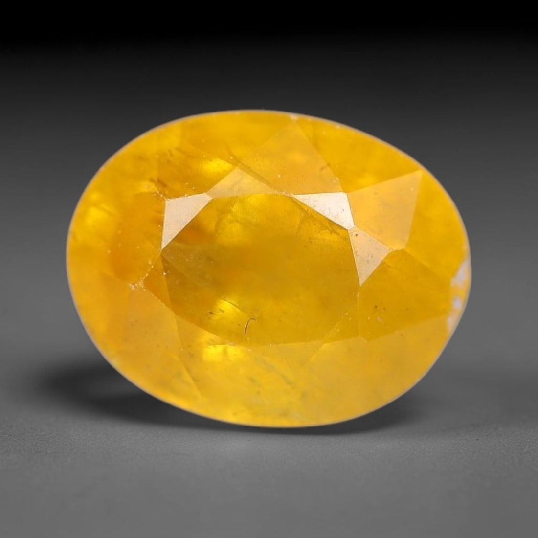 2.04 Carats Natural Yellow Sapphire Oval Faceted Loose Gemstone, 75TT: This natural yellow sapphire features a classic oval brilliant faceted cut, holding consistent warm golden-yellow color throughout the corundum crystal. Fine microscopic mineral specks and faint natur